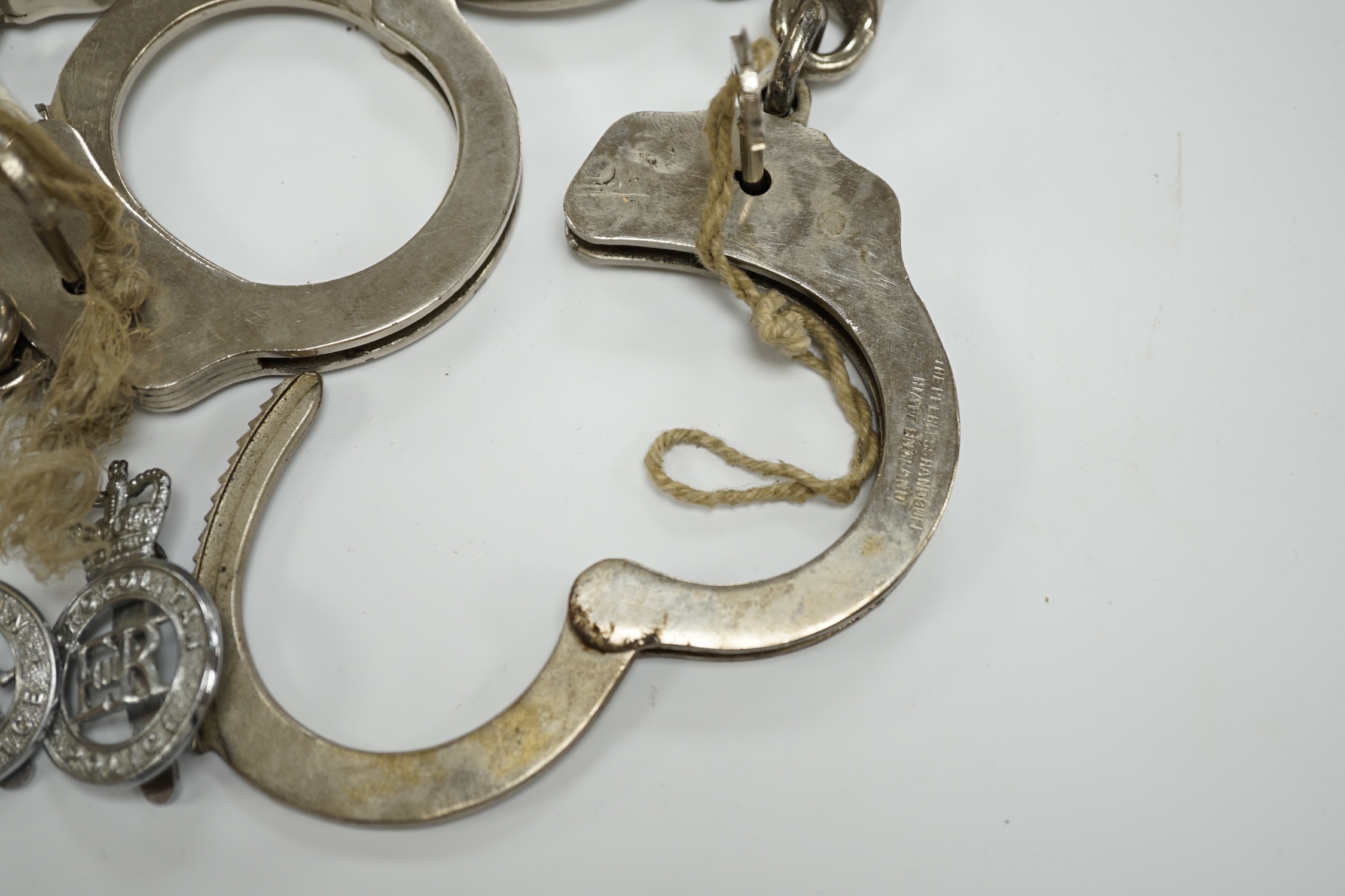 Three handcuffs, two with keys and two Metropolitan Police badges